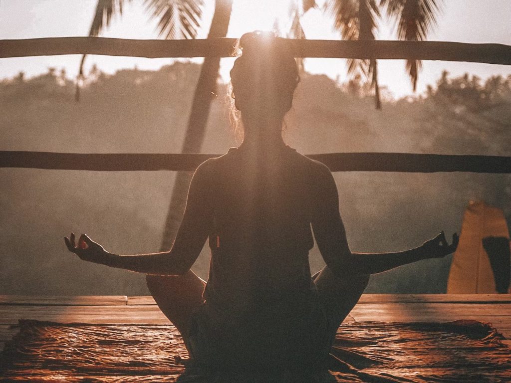 夕陽を浴びながら瞑想する女性